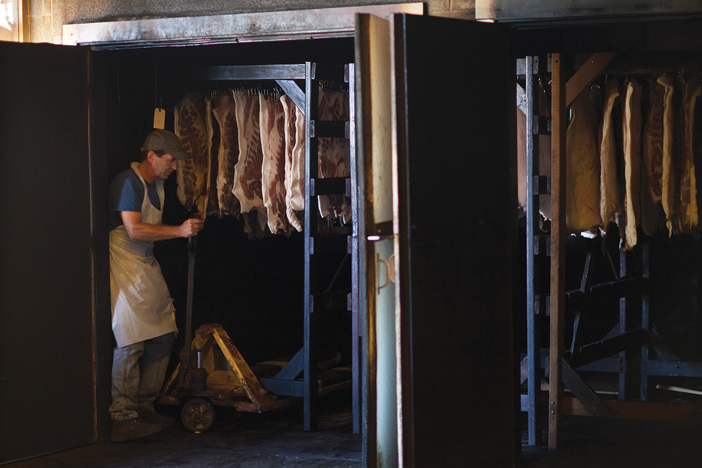 A rack of bacon is placed in the smokehouse. 