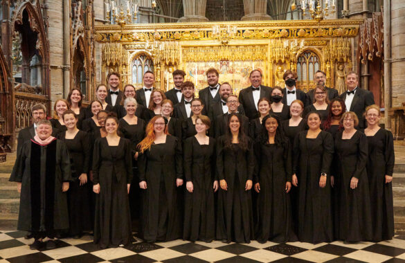 The choir, in formal black attire, poses for a photo in Westminster Abbey