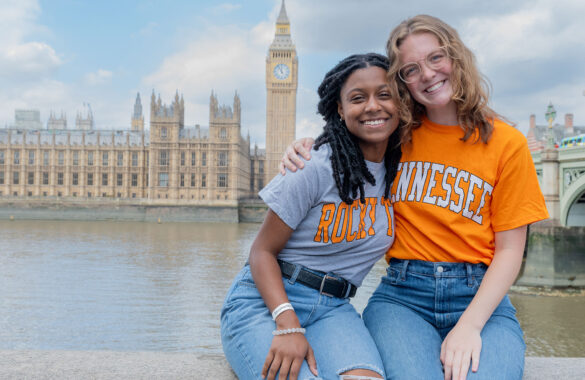 Two Tennessee students smile with arms around each other in London with the Thames and Parliament in the background