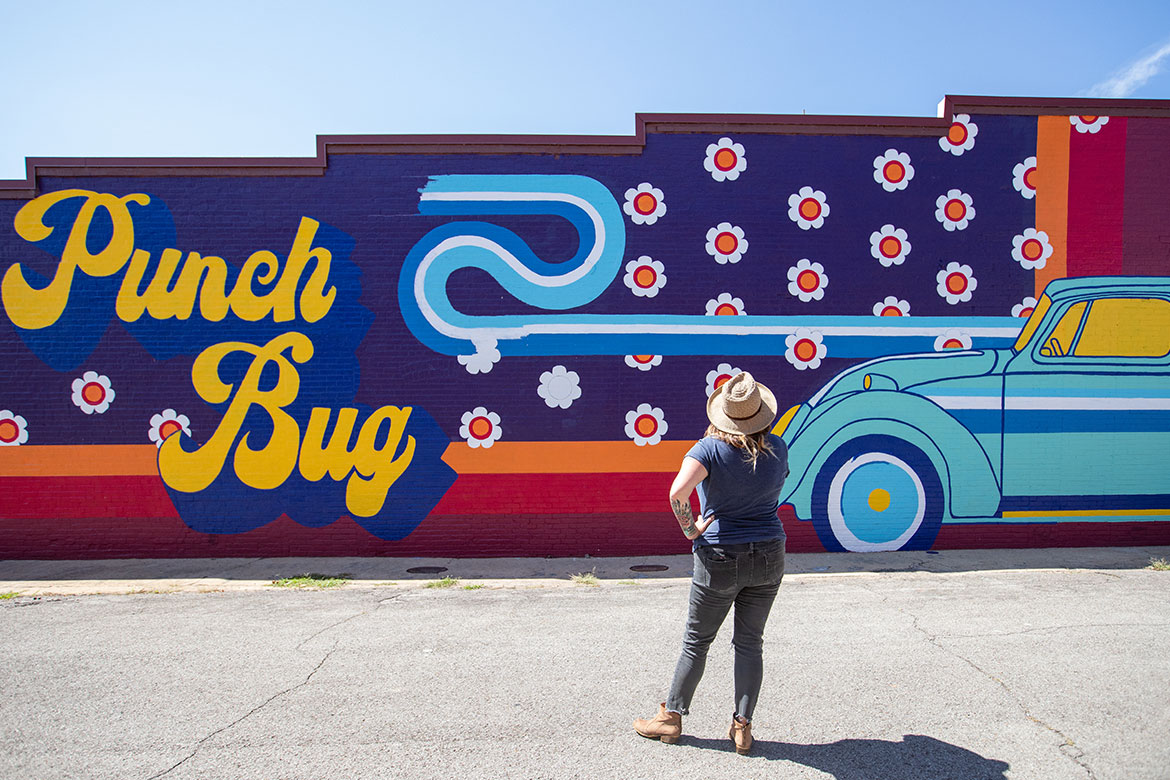 Woman standing in front of mural