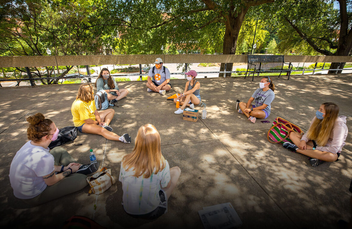 A group of leadership students sits in a circle outside the Humanities Building