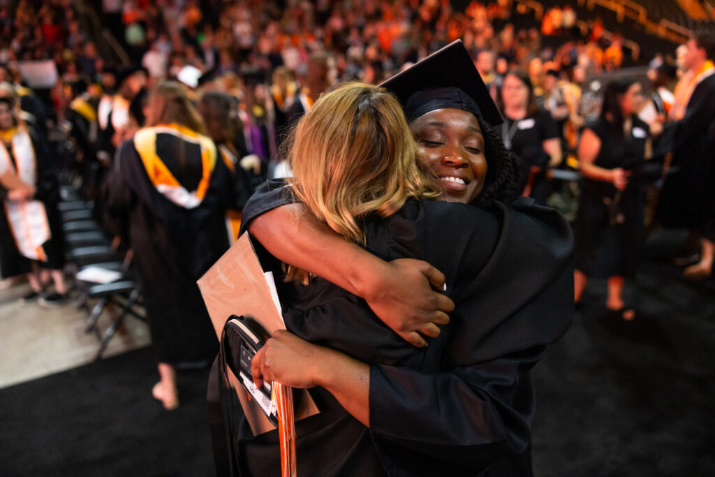 Two people hugging at a graduation ceremony