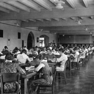 In this historical photo, we see rows of students at desks studying in Hoskins Library.