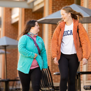 Callie Canfield and her best buddy Elise McDaniel walk across campus during class change, talking and laughing.