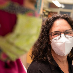 Amy Murndorff smiles behind her N95 mask as she talks with a graduate student in her lab.