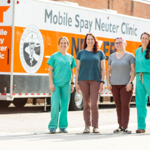 Four veterinarians stand outside the mobile spay and neuter clinic.