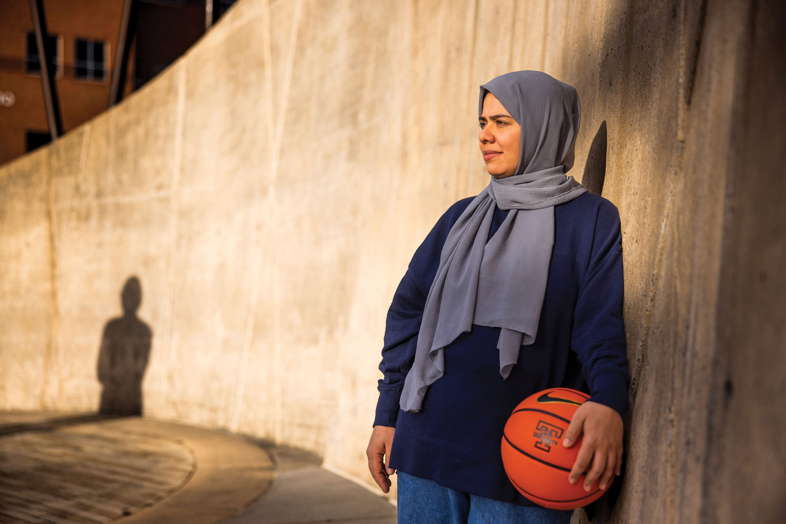 Malalai Anwari leans on a wall with the shadow of Pat Summitt's statue in the background