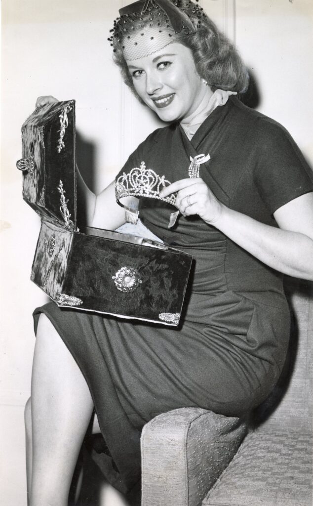 A woman holds a box and a tiara