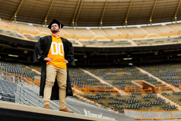 Connor, wearing his cap and gown, gazes off into the distance