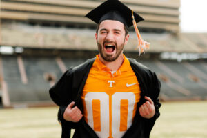 Connor Solsbee pulls his robe aside to reveal Mascot Smokey's jersey